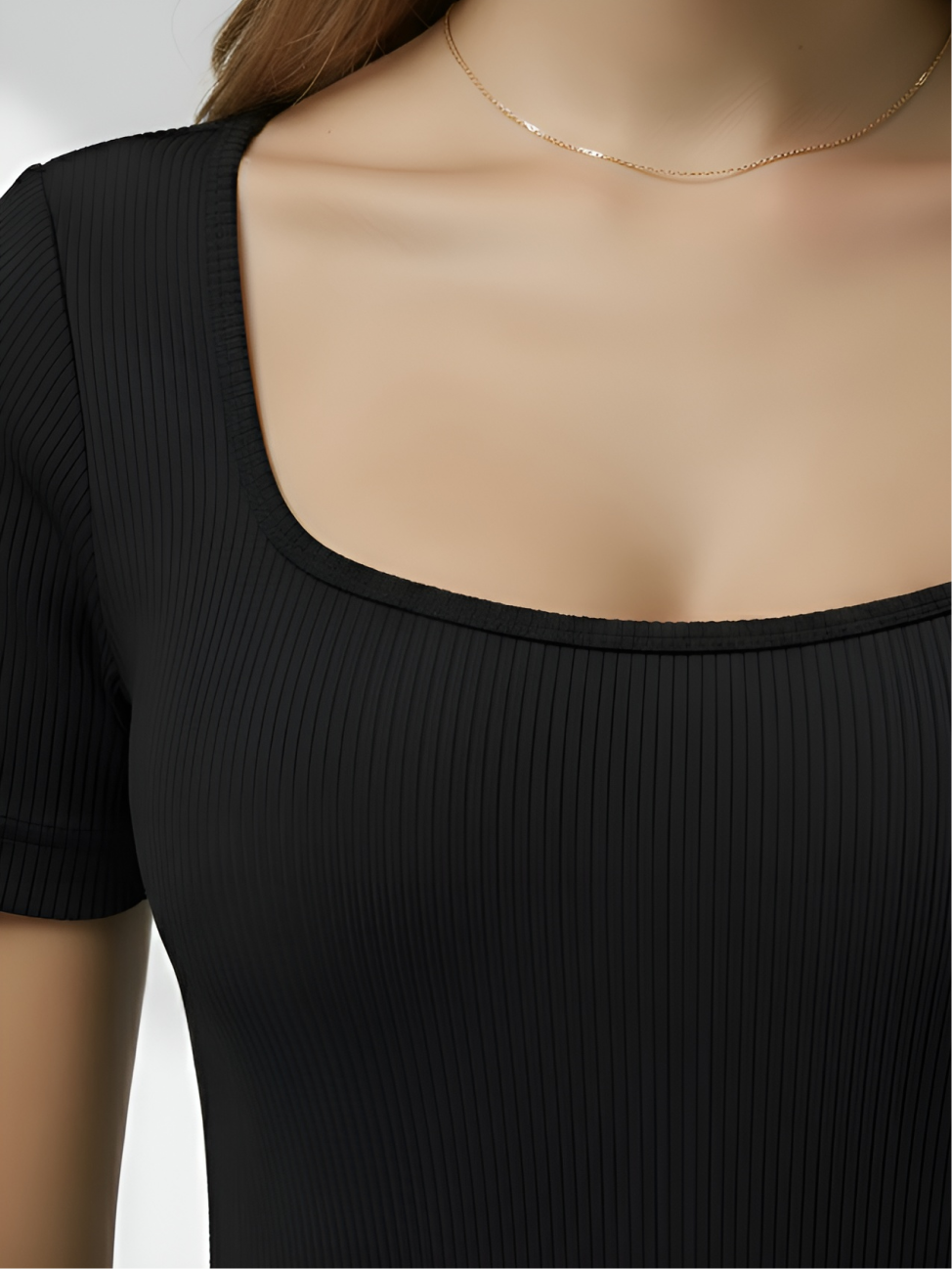 Close-up of black square neck bodysuit with ribbed stretch fabric and smooth neckline