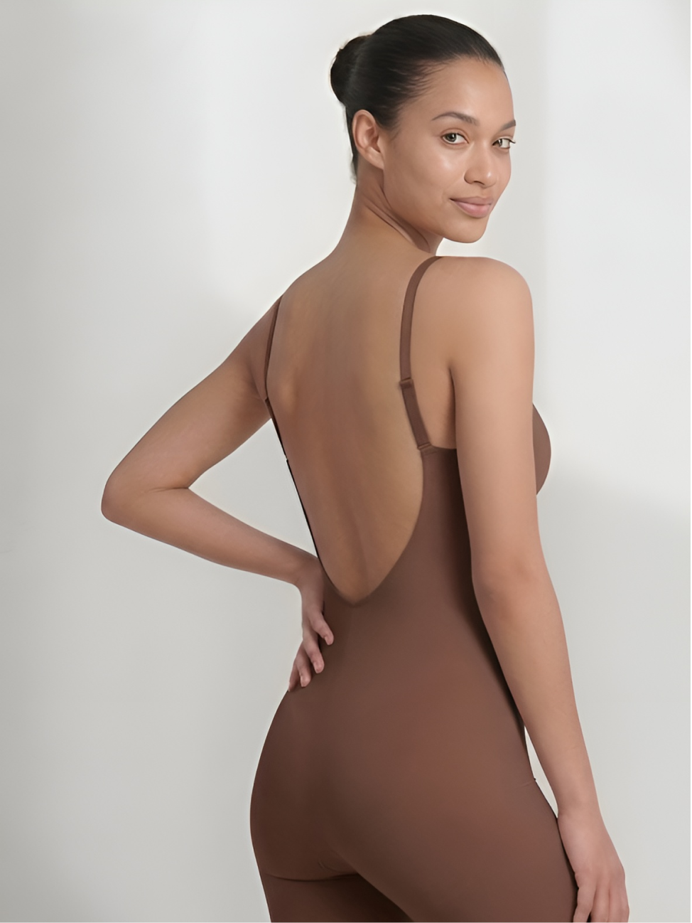 Angled back view of brown backless bodysuit with shorts and low open back
