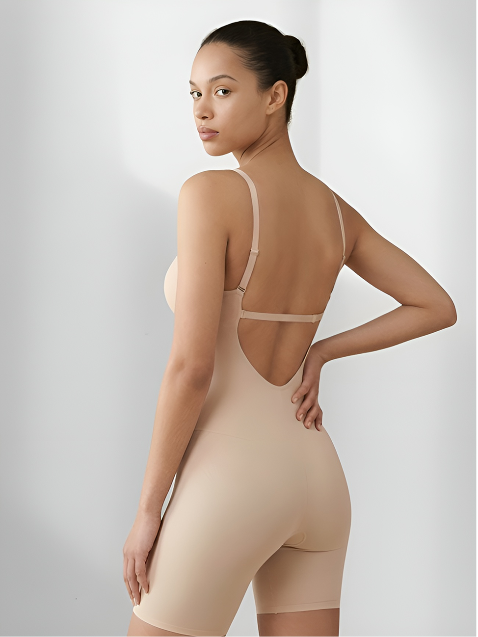 Angled back view of tan backless shorts bodysuit with open back and sculpting support
